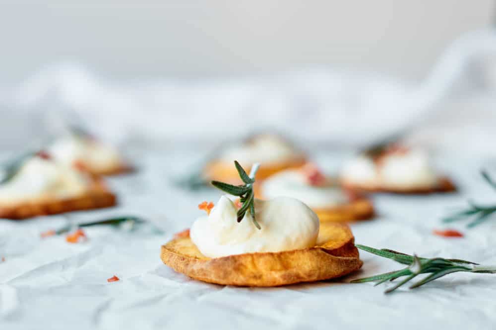 Sweet Potato Rounds With Greek yogurt, bacon bits and fresh rosemary.