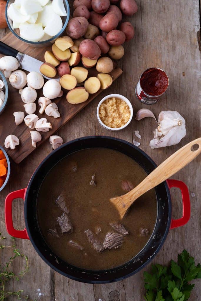 Beef and broth in Dutch oven.