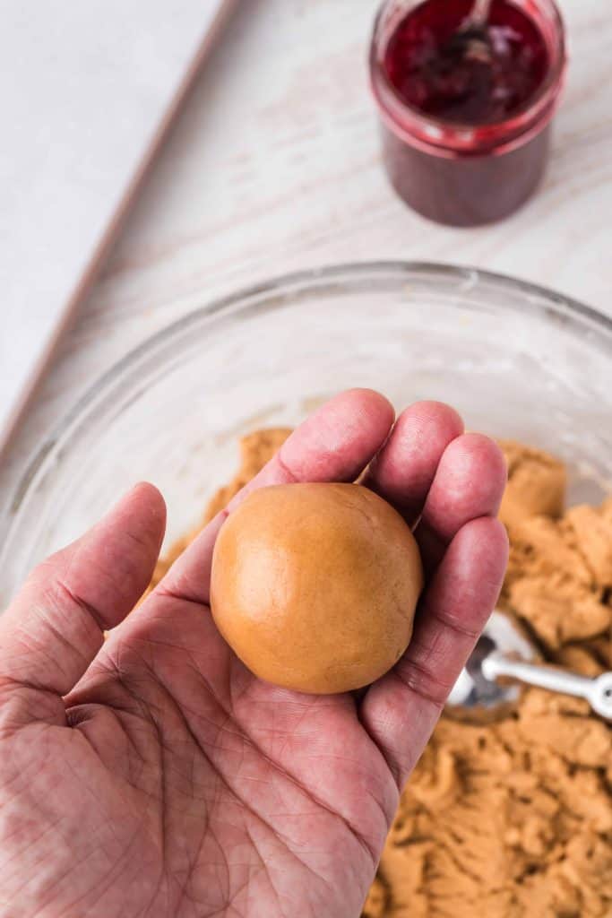 Peanut butter cookie dough ball in palm of hand.
