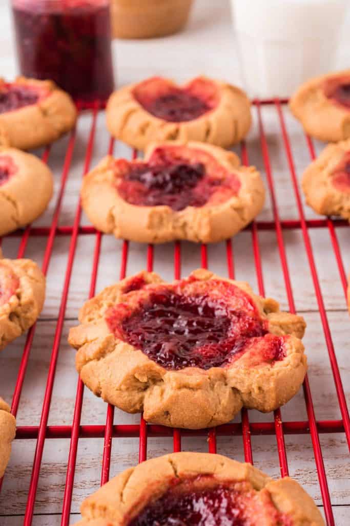 Peanut butter and jam cookies cooling on a wire rack.