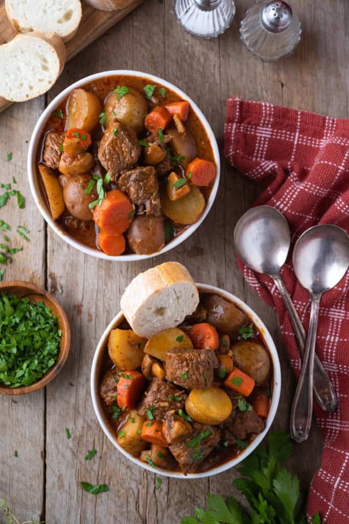 Overhead view of two bowls of beef stew with vegetables.