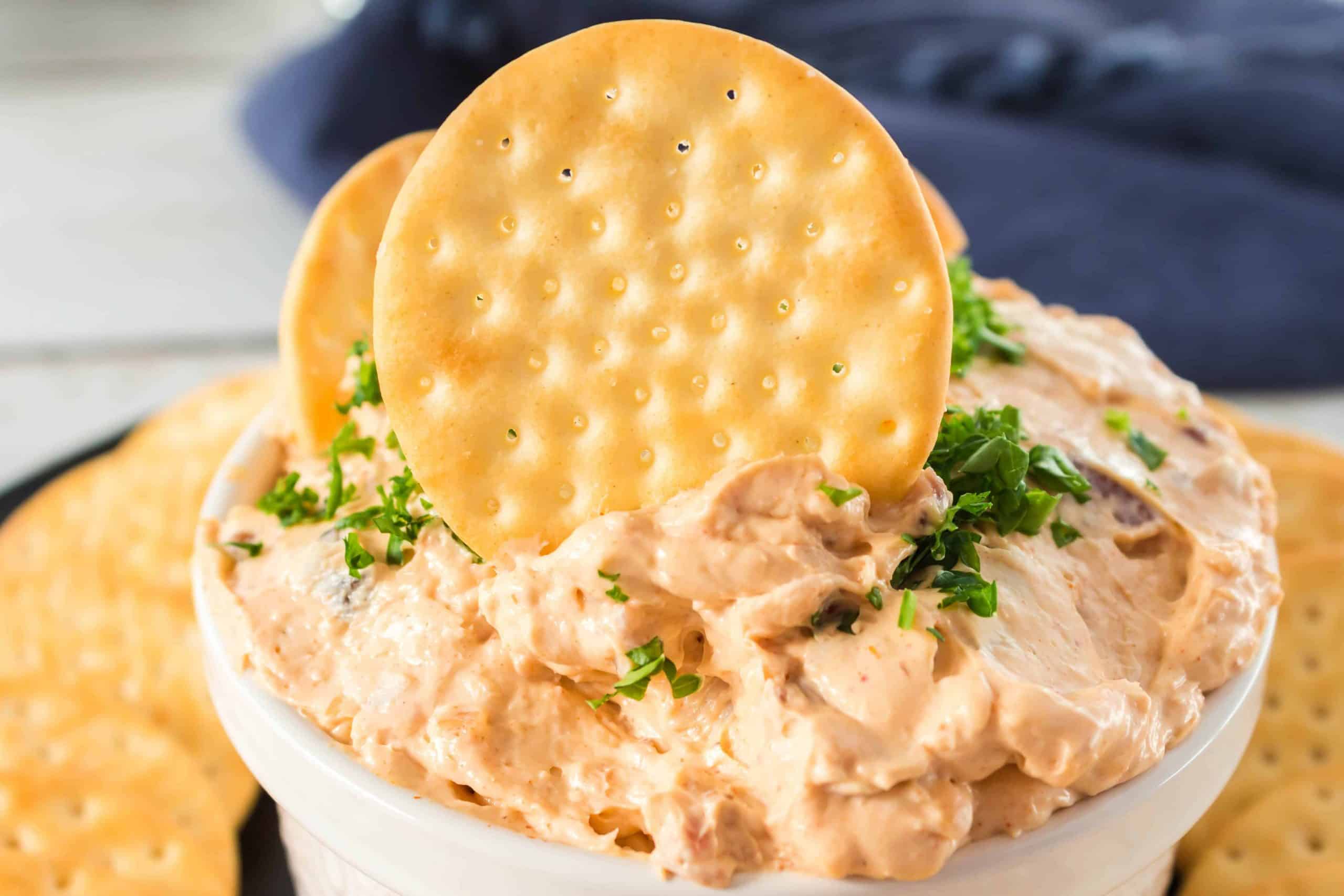 Chicken Spread in a bowl with crackers on top.