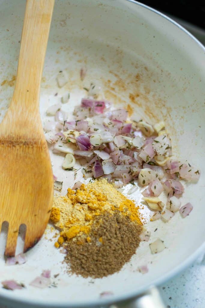 Sauté pan with diced red onion and spices.
