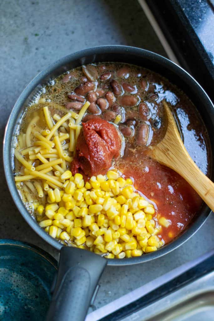 Add broth, macaroni, tomatoes, beans and corn and boil