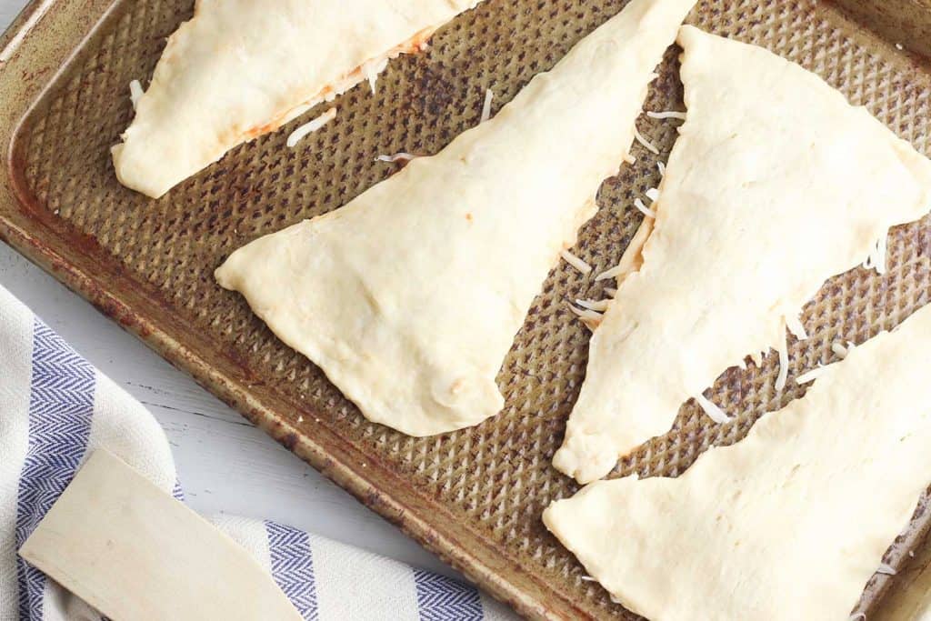 Crescent Roll Pizza Pockets on a baking sheet ready to go in the oven.