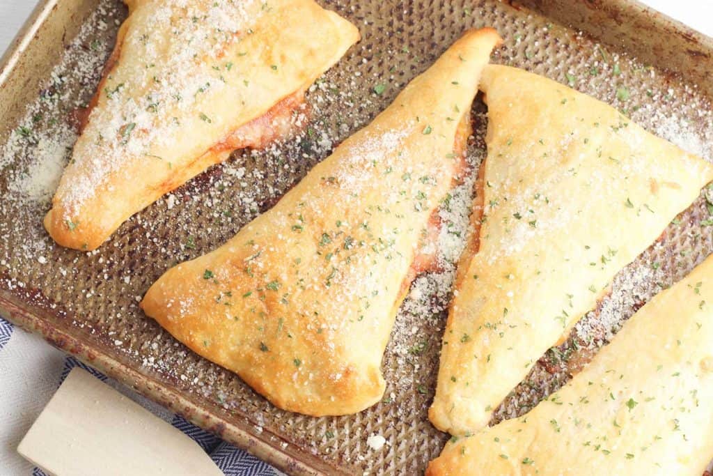 Pizza Pockets hot out of the oven on a baking sheet.