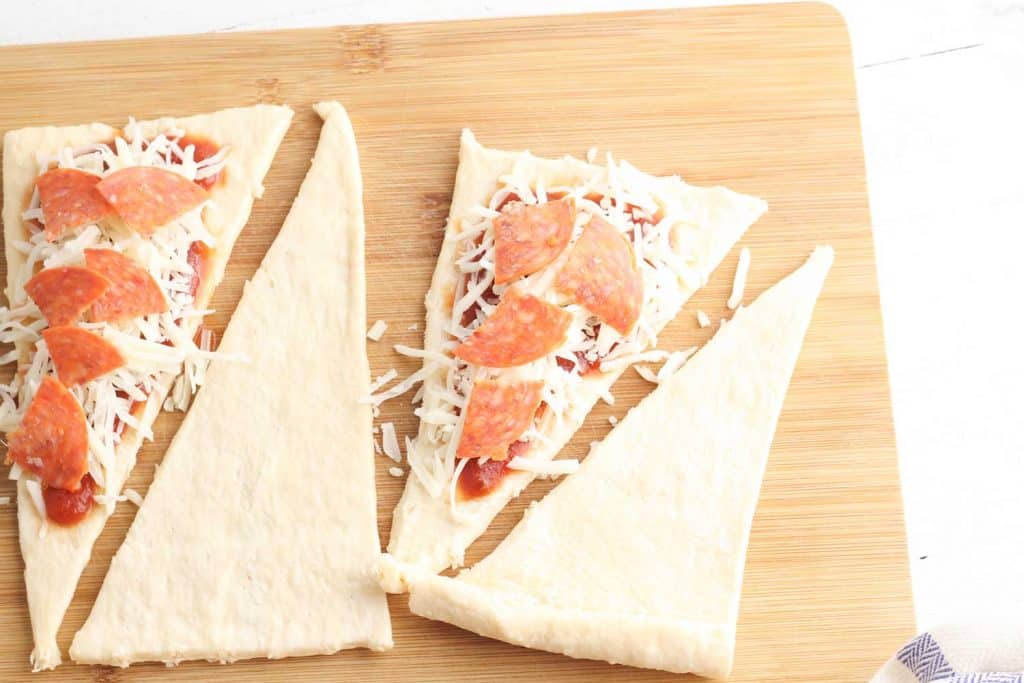 Pepperoni, cheese and sauce on top of Crescent Roll dough.