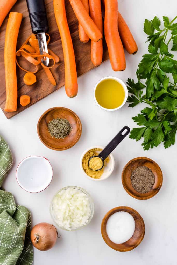 Ingredients for Oven roasted carrots on a white backgound.