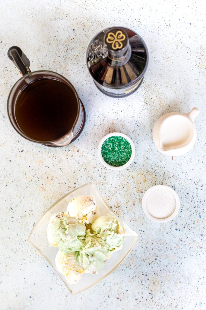 Overhead view of cold brew coffee, green sprinkles, pistachio ice cream, sugar and sweet cream