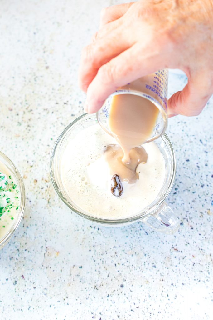 Irish cream Liqueur being drizzle into cup with ice cream and sweet cream.