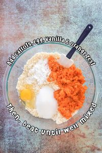 Mashed carrots, flour, sugar and eggs in a large glass bowl.