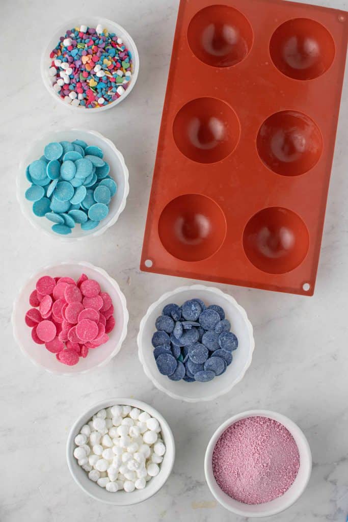 Ingredients for Galaxy Hot Cocoa Bombs beside silicone half sphere mold.