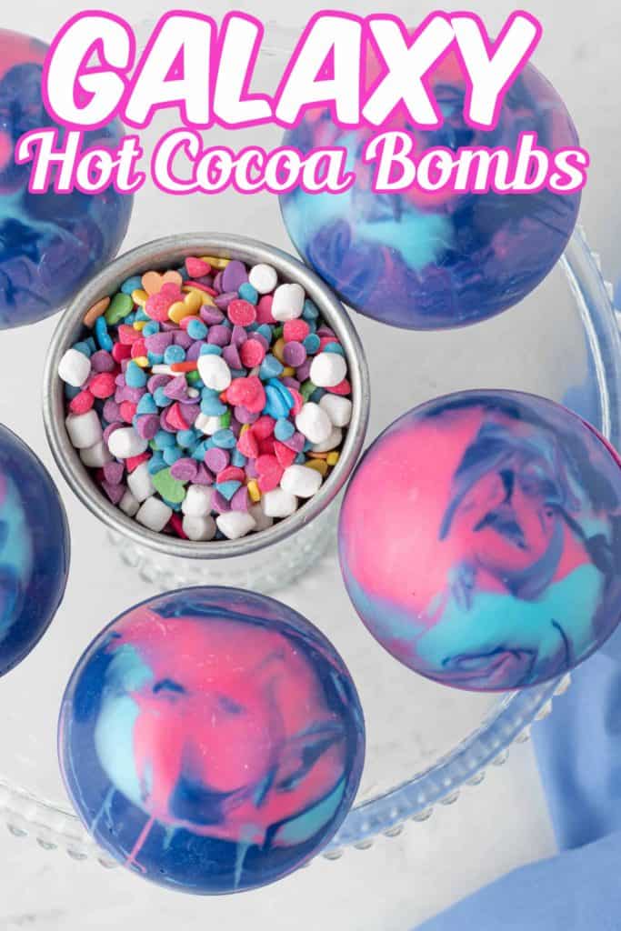 Overhead photo of Galaxy Hot Cocoa Bombs with multi colored sprinkles in the center and text overlay.