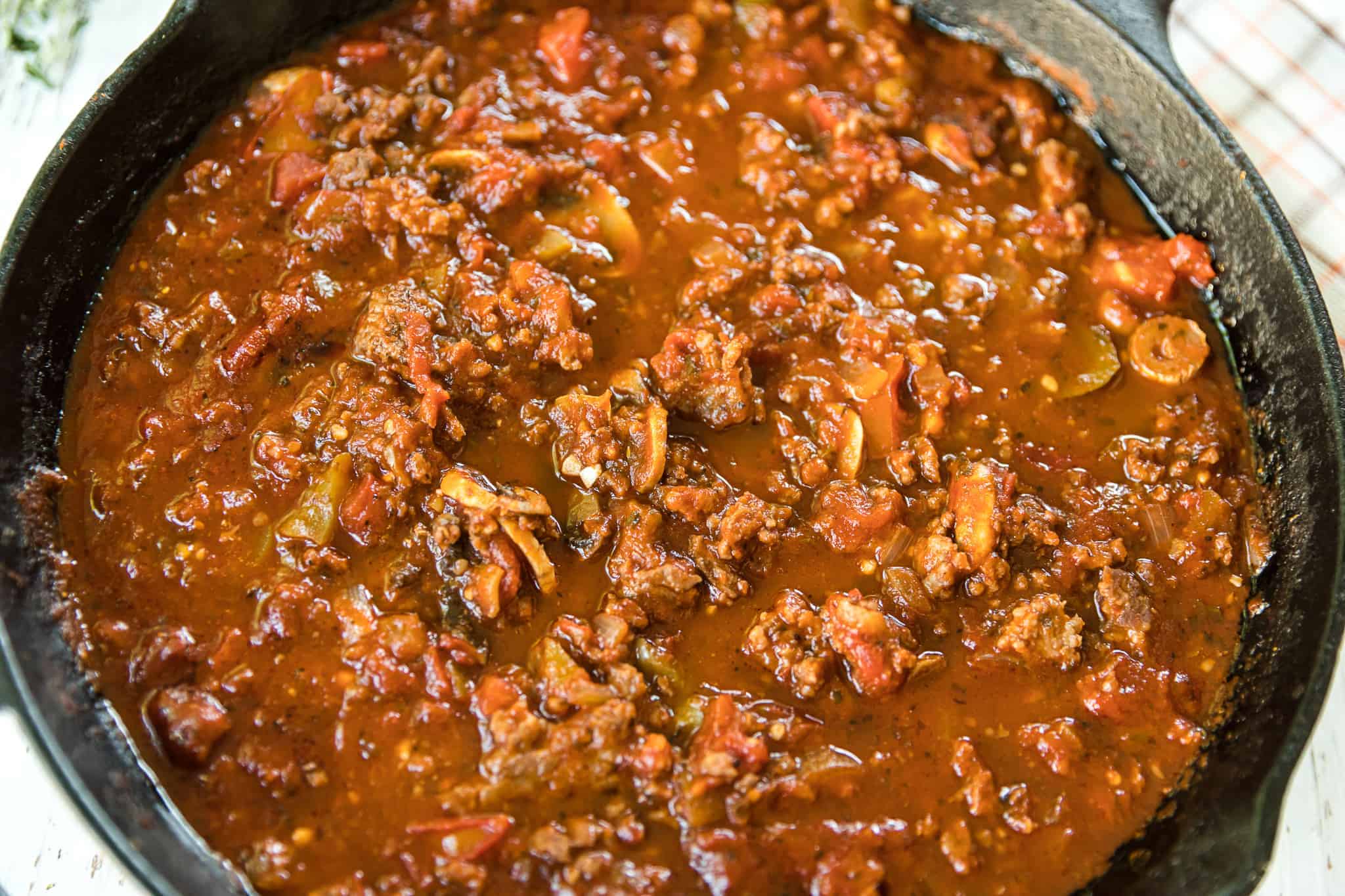 Closeup of meat sauce in a black iron skillet.