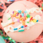Closeup photo of pink hot cocoa bomb with sprinkles.