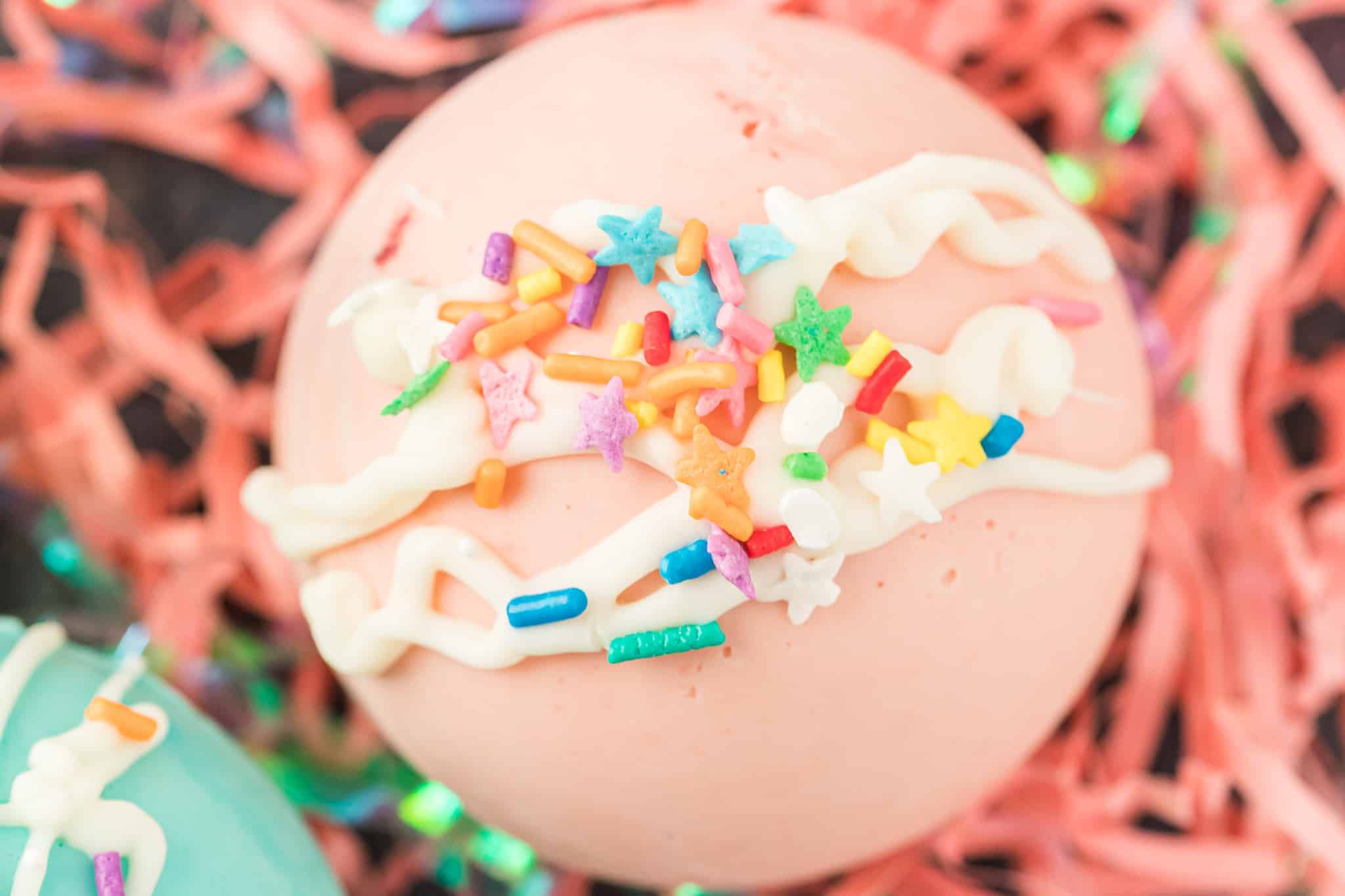 Closeup photo of pink hot cocoa bomb with sprinkles.