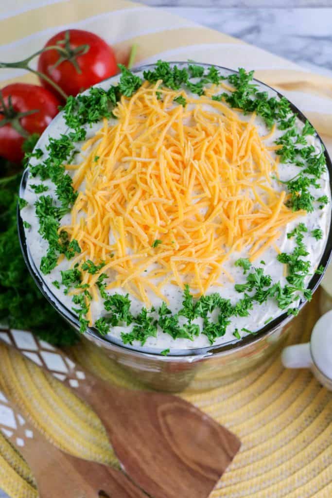 Overhead view of layered salad with sour cream, cheddar cheese and green onions