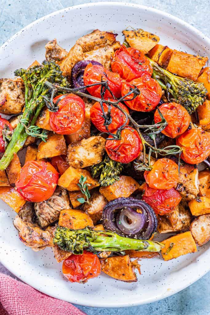 Overhead view of white bowl filled with roasted vegetables and chicken