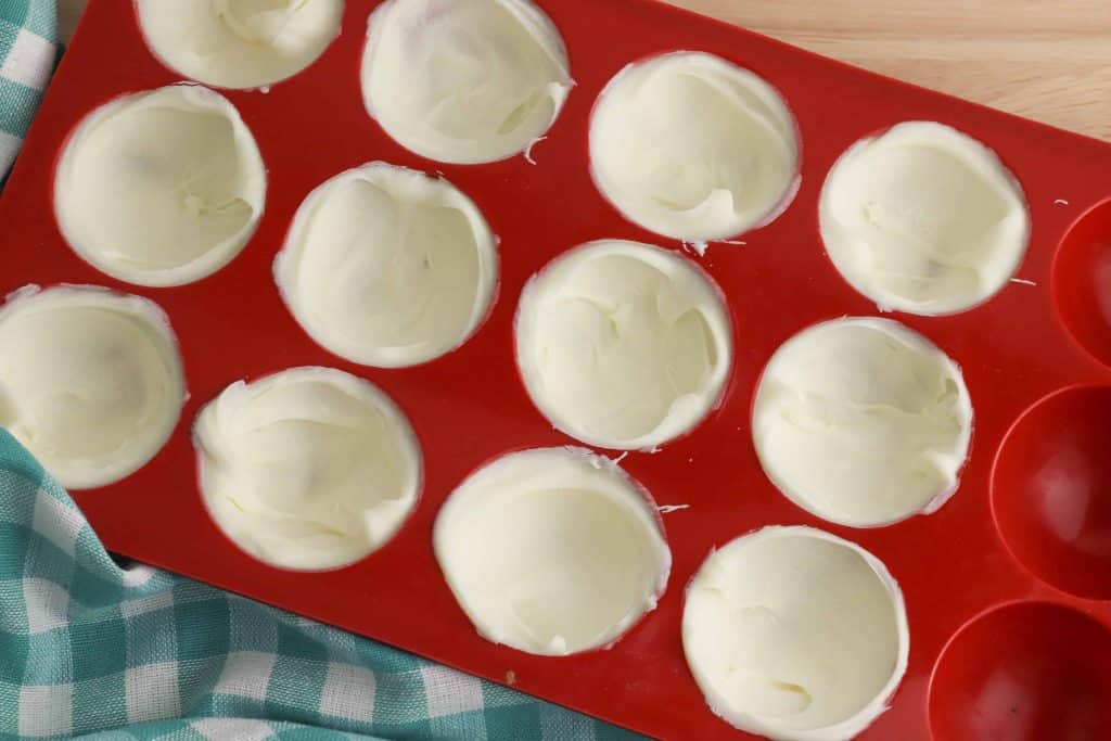 White chocolate in half of red silicone mold.