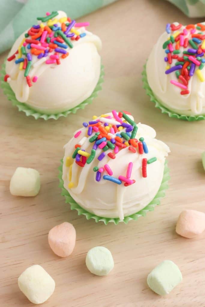 ¾ angle view of White Chocolate Hot Chocolate Bombs with rainbow sprinkles on top.