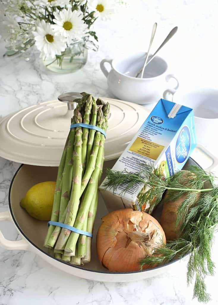 Ingredients for Asparagus Soup in a large white pot