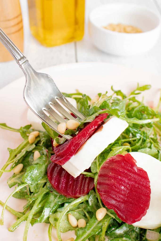 Beet salad with mozzarella cheese on a fork.