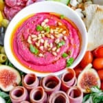Roasted beet hummus in the center of a charcuterie platter.
