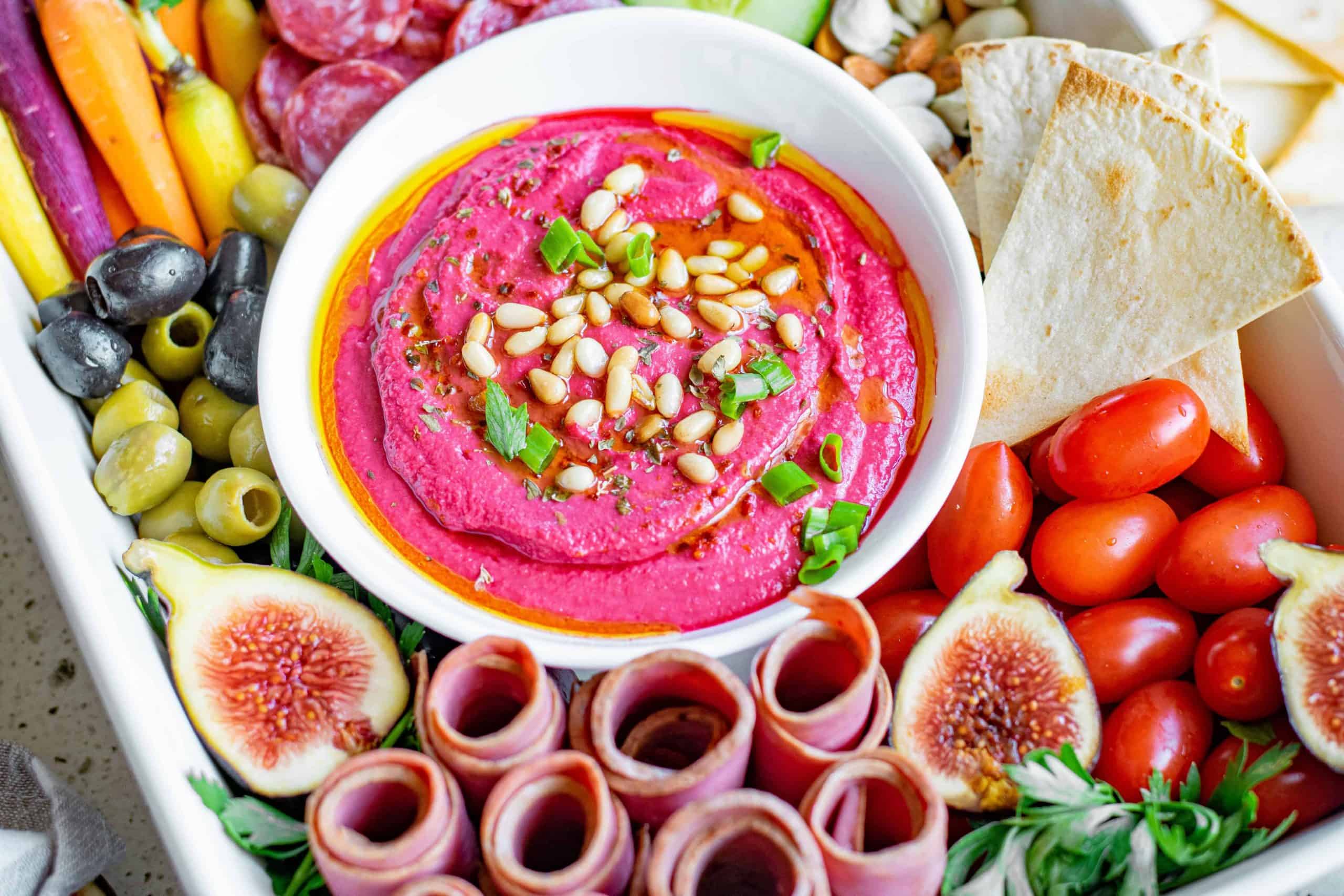 Roasted beet hummus in the center of a charcuterie platter.