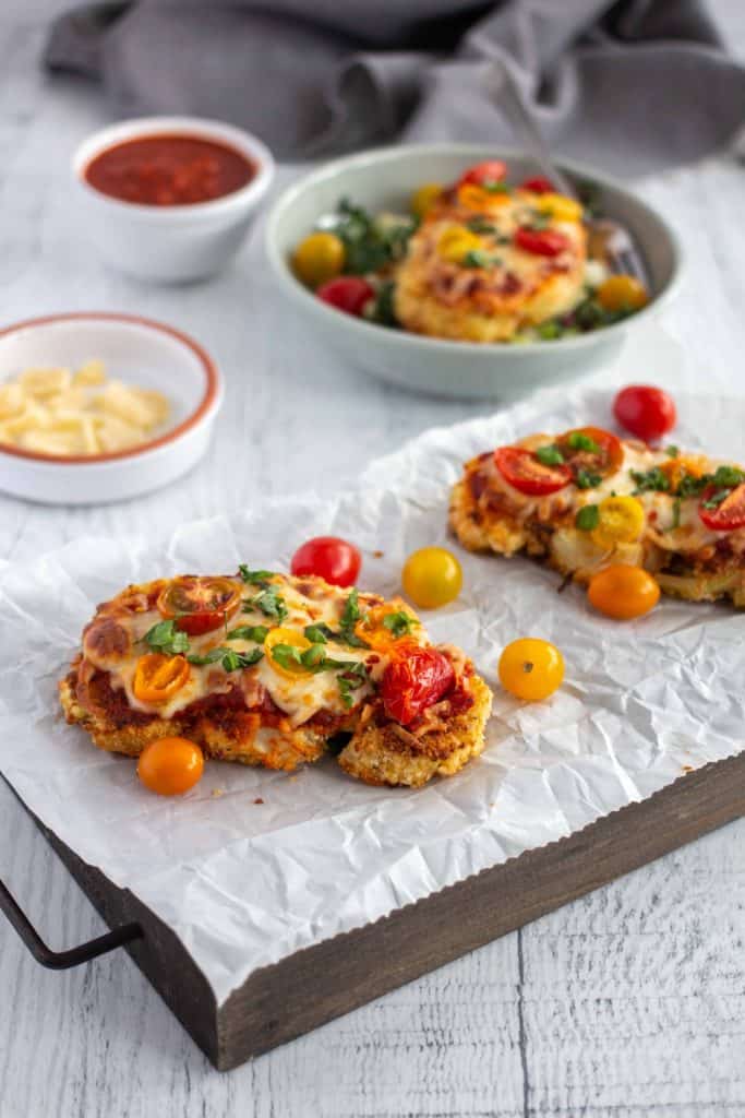 Side view of cauliflower with cheese and cherry tomatoes.