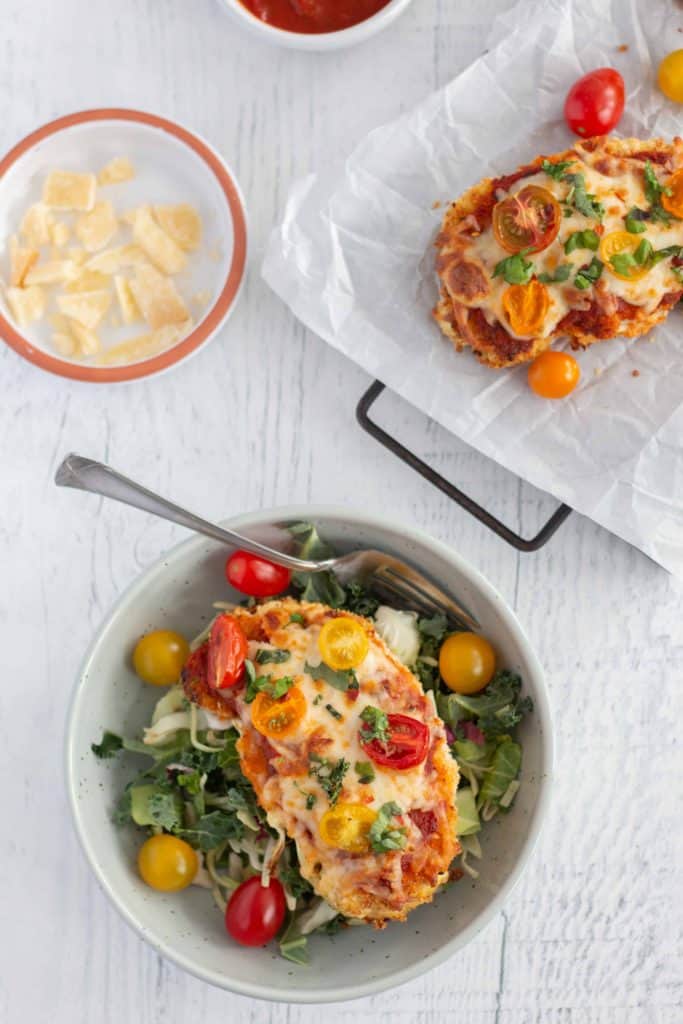 Cauliflower Parmesan in a bowl on a bed of greens.