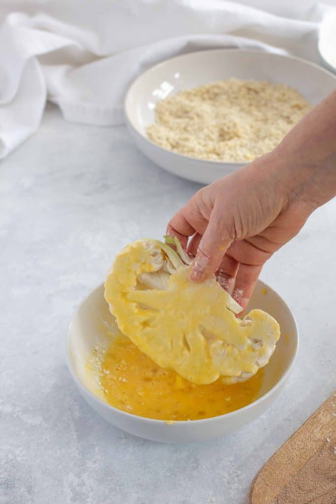 Coating cauliflower with egg.