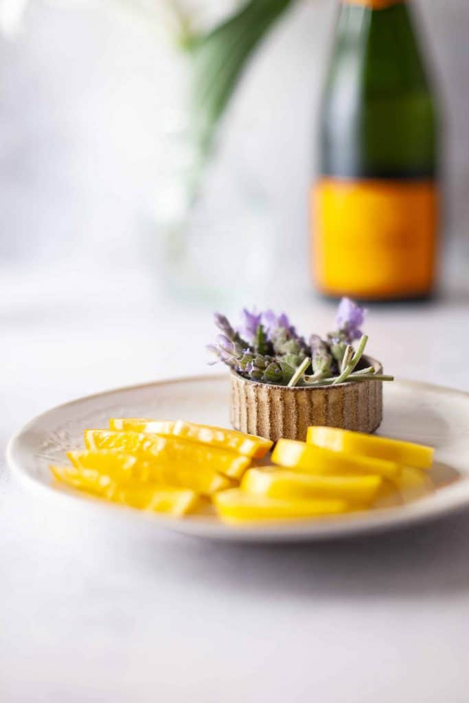 Plate with fresh lemon slices and flowers.