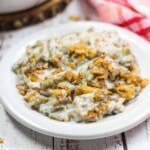 Overhead view of canned soup, canned vegetables and fried onions on a white background.