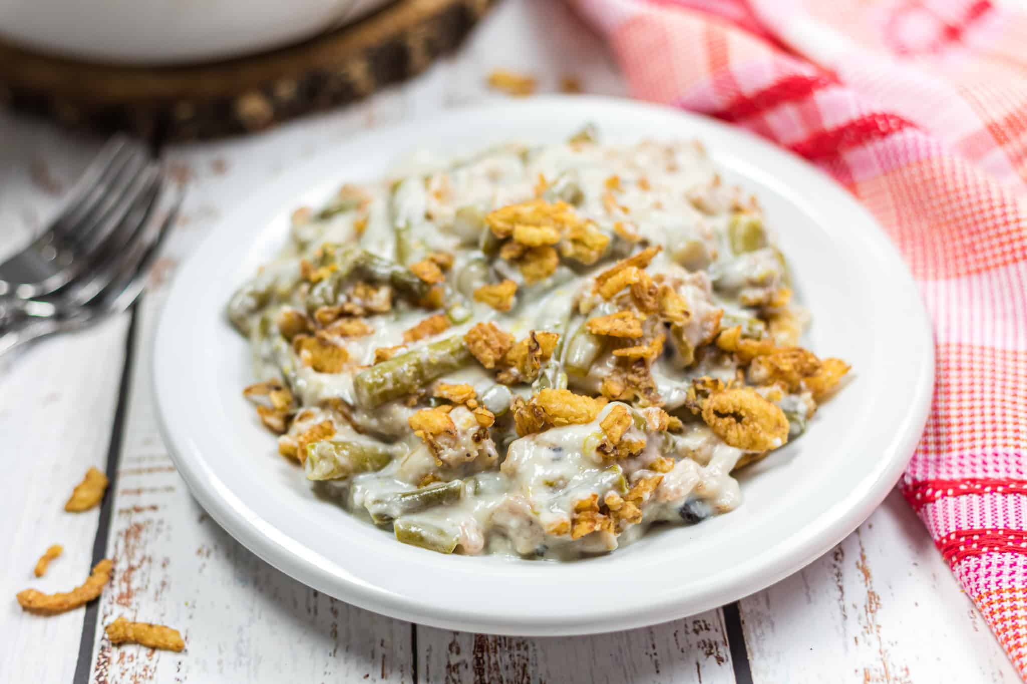 Overhead view of canned soup, canned vegetables and fried onions on a white background.