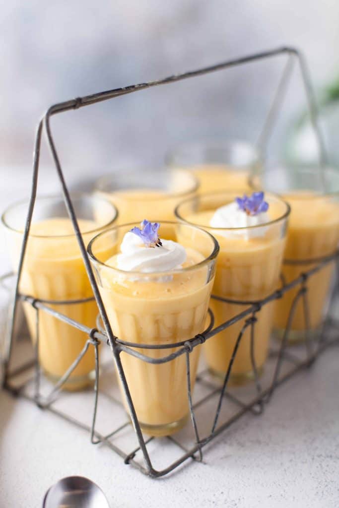 Six orange drinks in a metal carrying tray.