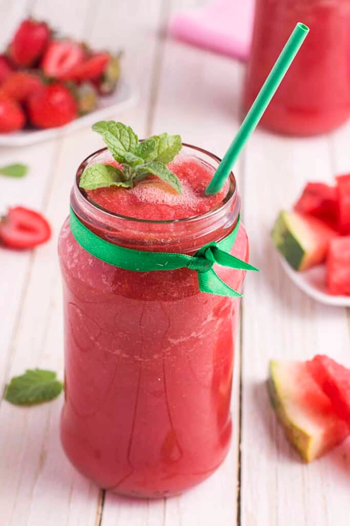 Strawberry Smoothie in a glass with a green bow tied around it.