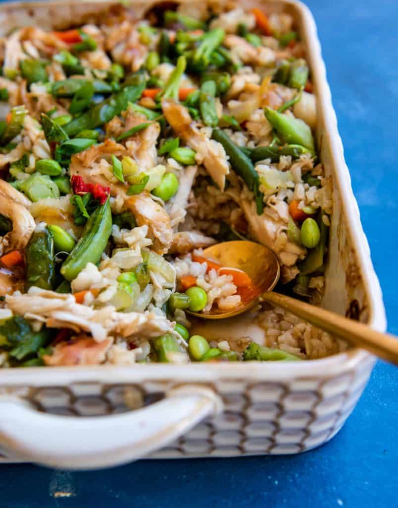 Chicken Teriyaki Casserole with Rice in a baking dish with a wooden spoon in it.