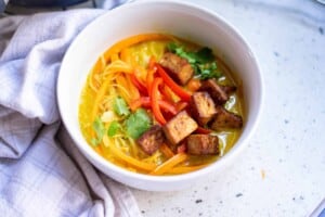 ¾ angle view of Vegan Thai Coconut Soup in a white bowl.