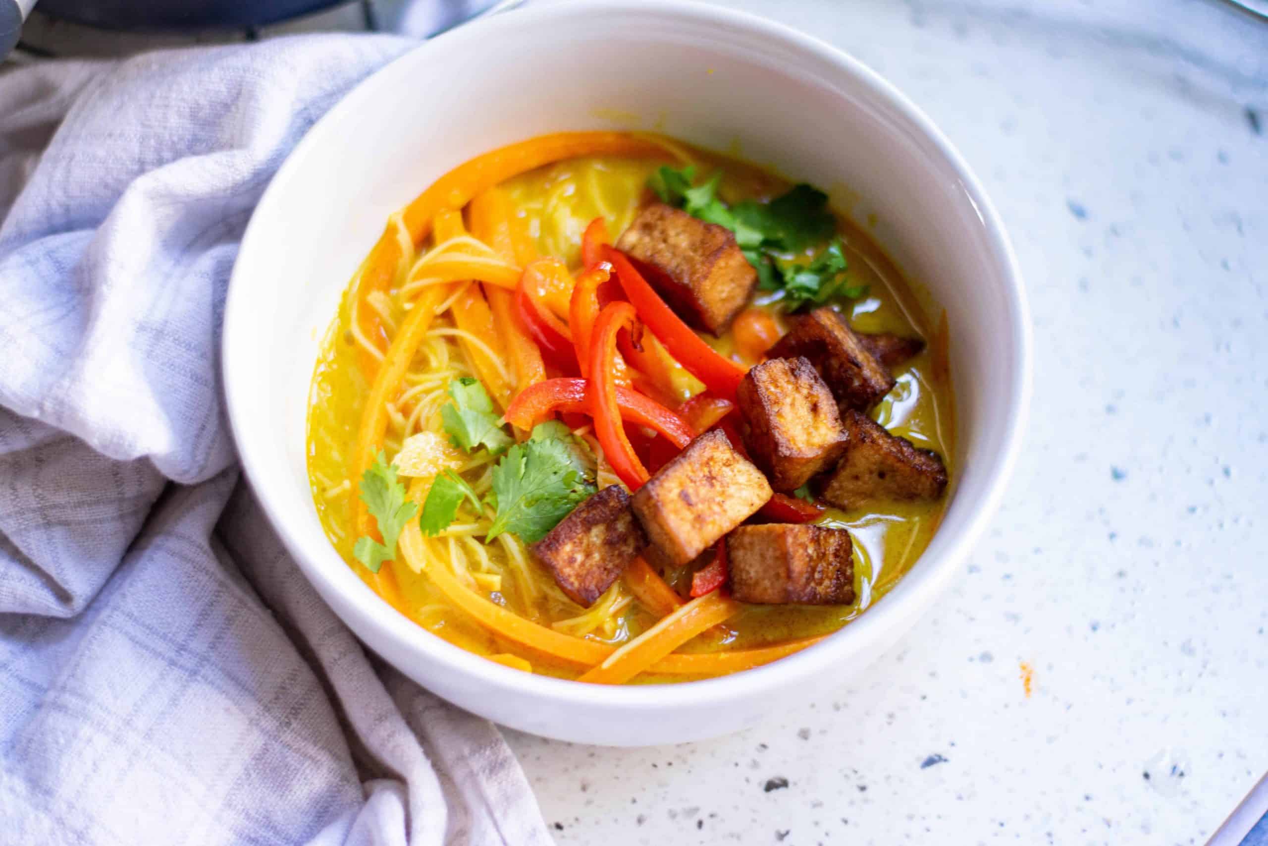 ¾ angle view of Vegan Thai Coconut Soup in a white bowl.