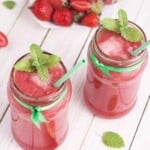 &frac34; angle view of 2 strawberry smoothies with fresh mint garnish.