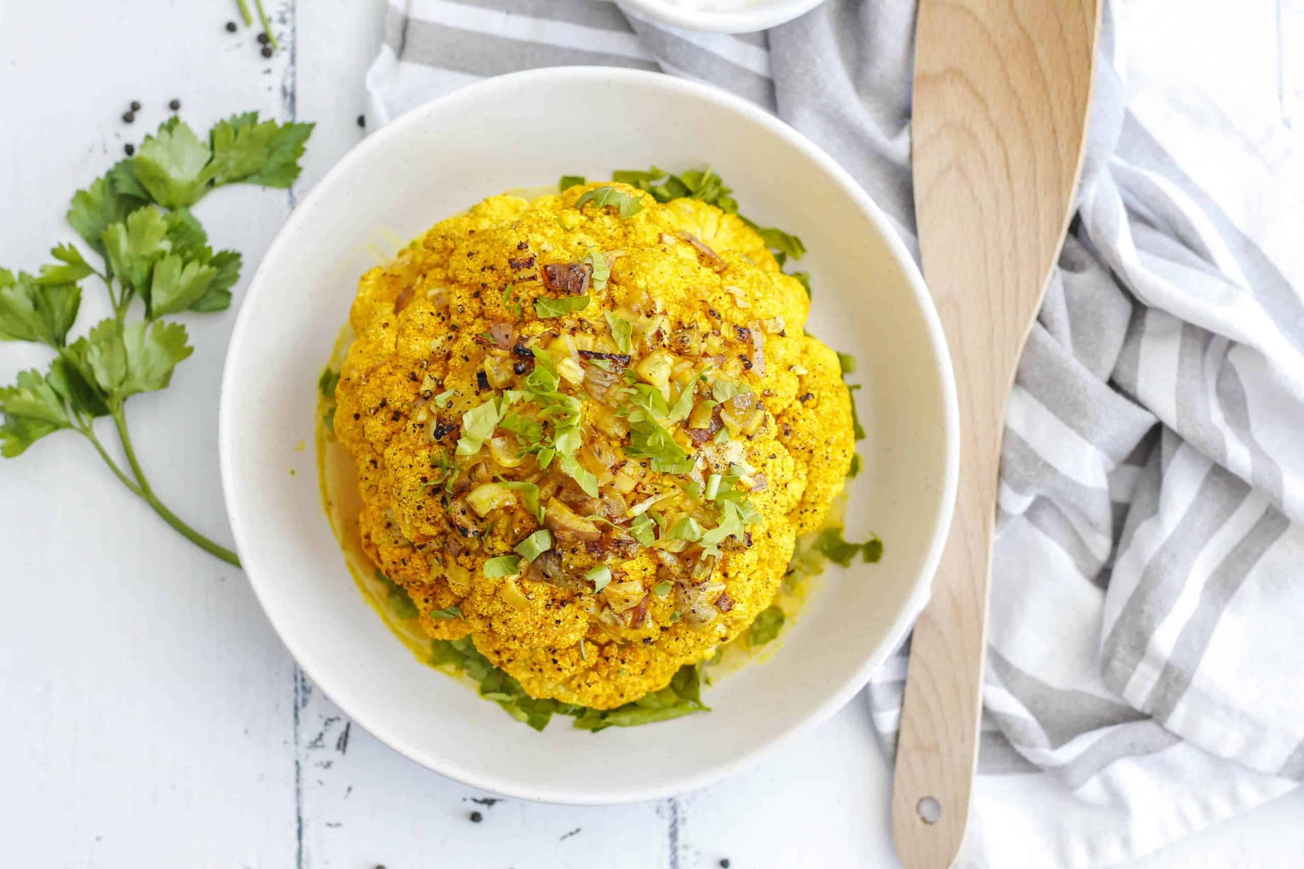 Overhead view of whole roasted head of cauliflower.