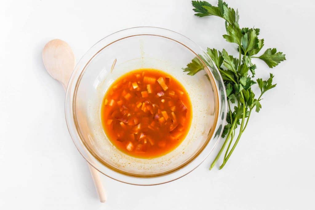Clear glass bowl with curry marinade.