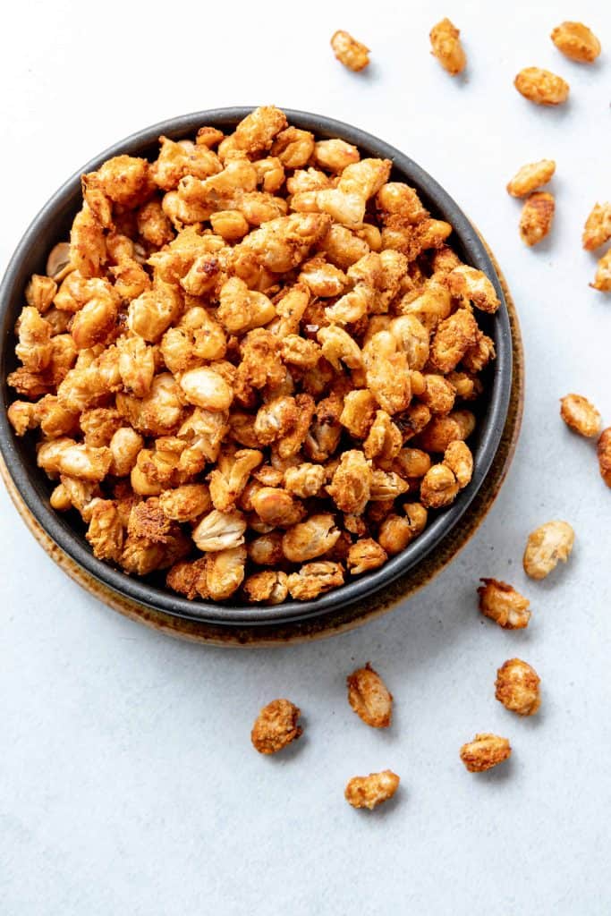 Overhead bowl of baked beans with seasonings.