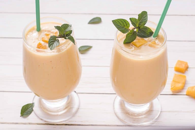 Too Mango Lassis side by side on a white wood background.