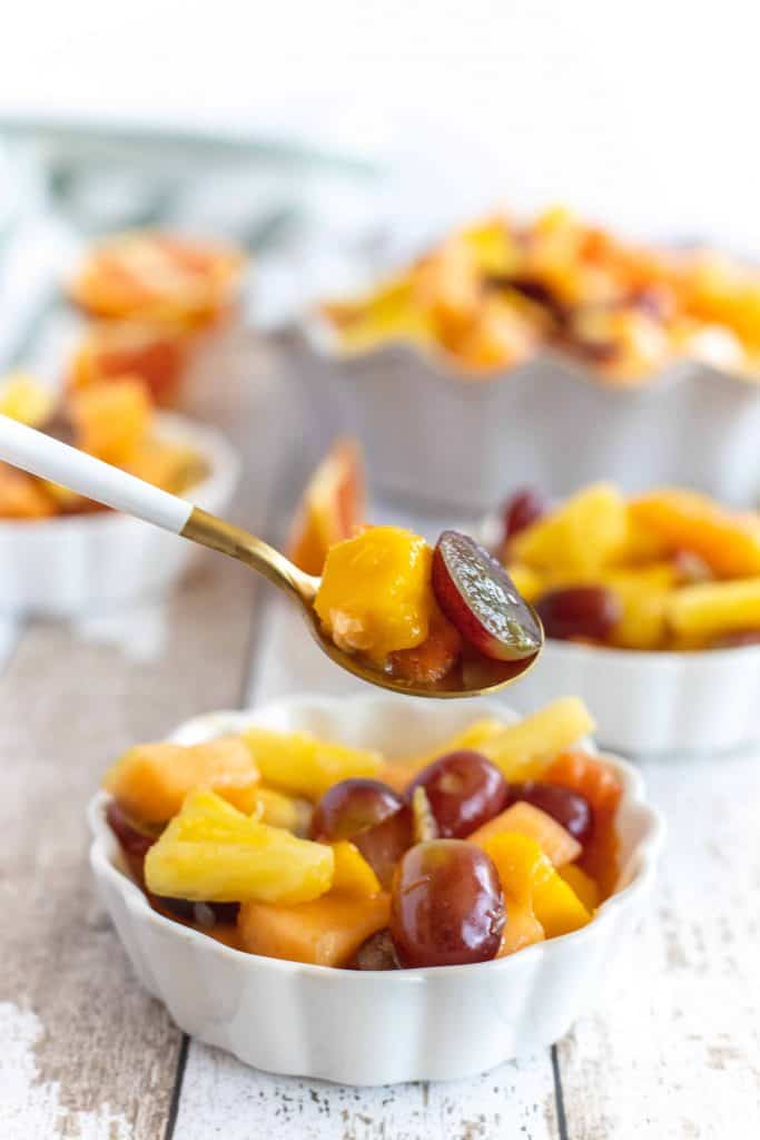 Close up of fruit cocktail on a spoon.