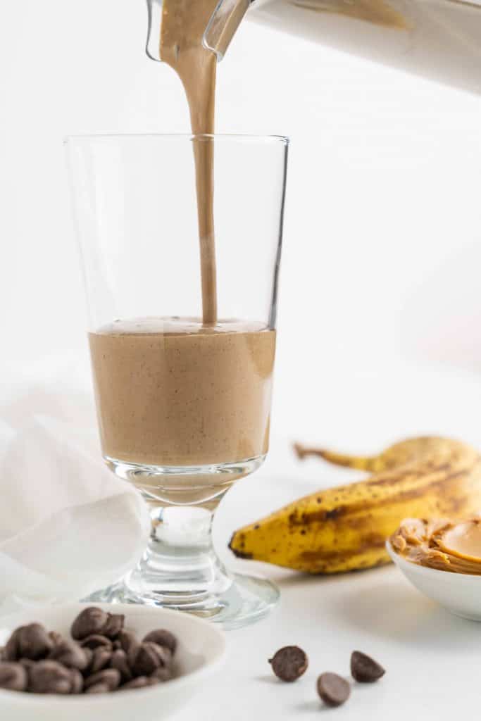 Healthy Chocolate Smoothie being poured into tall glass.