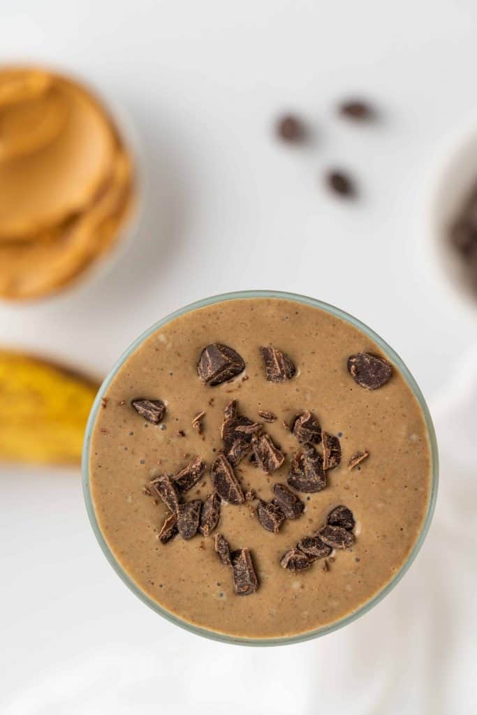 Overhead view of chocolate smoothie with chocolate chips sprinkled on top of it.