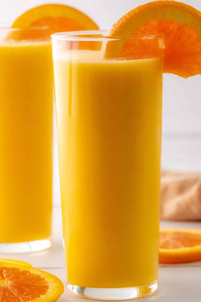 Head on shot of Orange Julius in a glass with orange slice garnish.