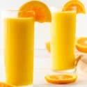 Side by side Orange Julius drinks with orange slices.