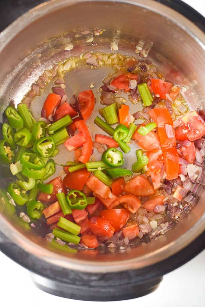 Diced tomatoes, jalapeños, garlic and onion in the bottom of instant pot.